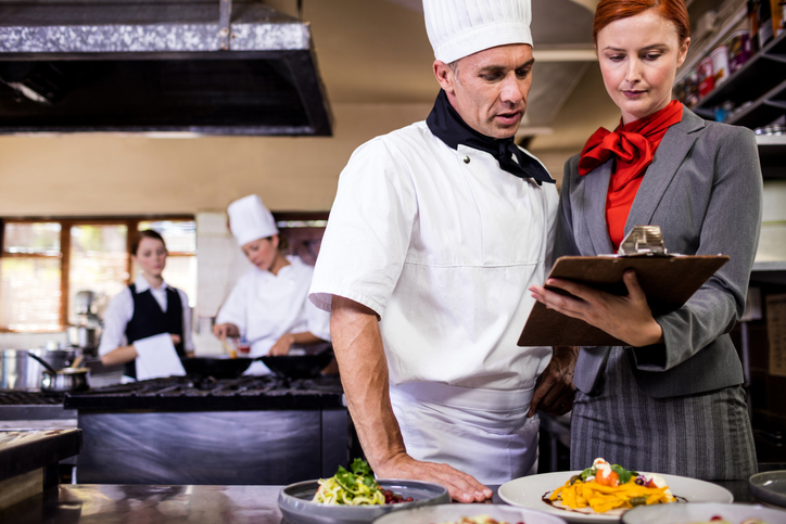 Health inspector showing results to restaurant chef